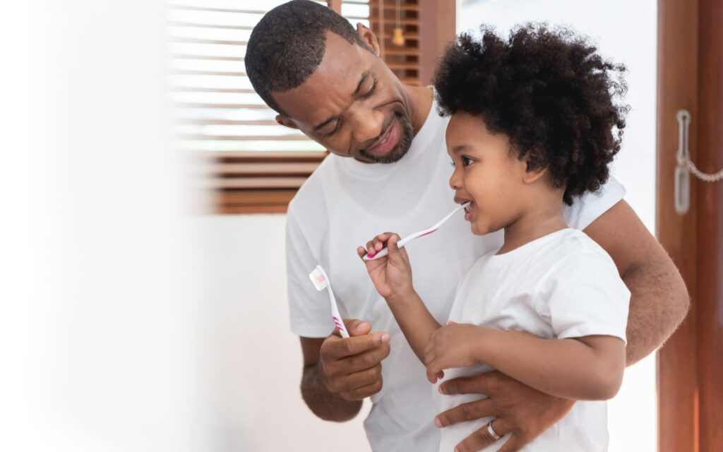 Father and daughter brushing teeth