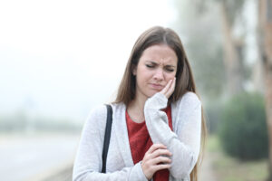 A woman holding her jaw in discomfort due to a severe toothache.