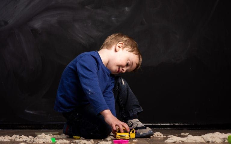 Child playing with toys against black background