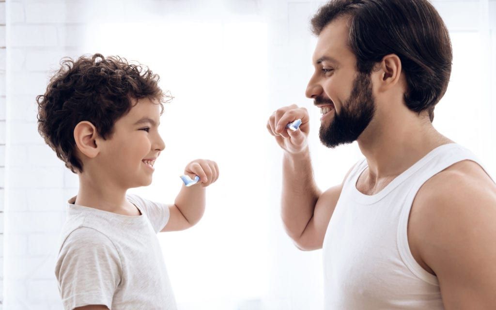 Parent and child brushing teeth