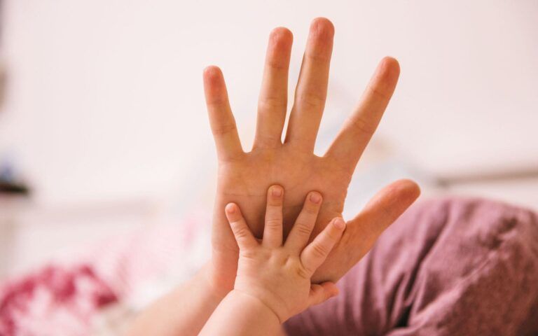 Infant Hand On Adult Hand