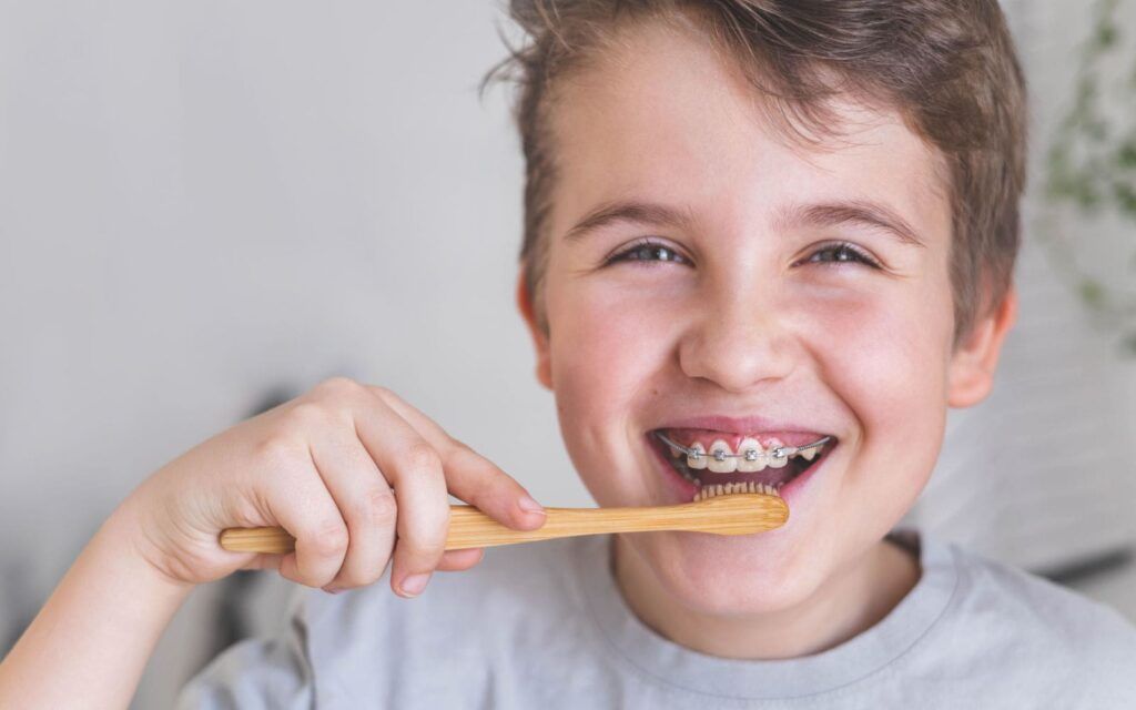 Boy Smiling Brushing Teeth With Braces